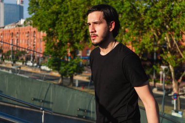 Genç Latin adam güneşli bir günde turist gezisinde büyük bir merdivene tırmanıyor.