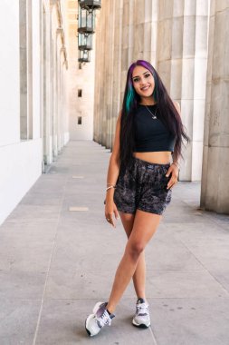 Geniş bir klasik binanın sütunları arasında genç bir kadının portresi.