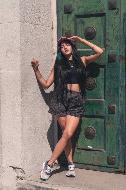 Genç bir kadın büyük eski bir kapıya yaslanıyor..