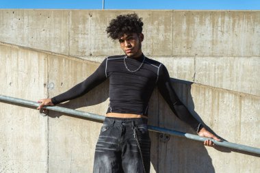 Beton bir merdivende ciddi bir ifadeyle genç bir İspanyol Afrikalı.