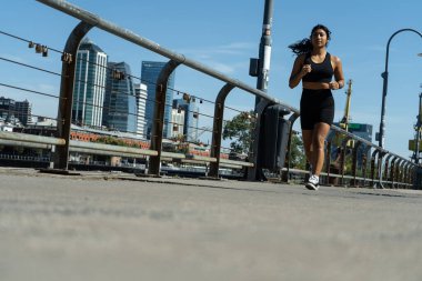 Buenos Aires şehrinde koşan genç bir atlet. Arka planda modern binalar var.