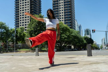 Şık bir dansçı şehir sokaklarında modern bir dans gösterisi sergiliyor.