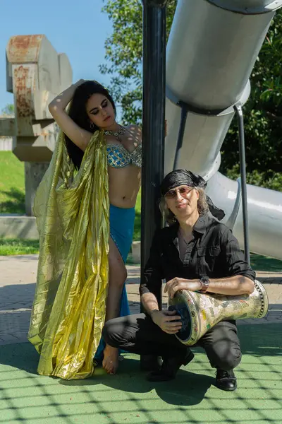 Odalisque ve darbuka oyuncusu Güneşin altındaki rüya gibi bir bahçede