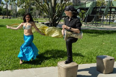 Bir Odalisque ve darbuka oyuncusu gündoğumunda enerji ve ritim dolu