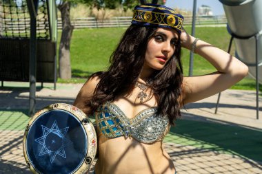 Gölgelerde Darbuka olan mavi elbiseli bir Arap dansçı.