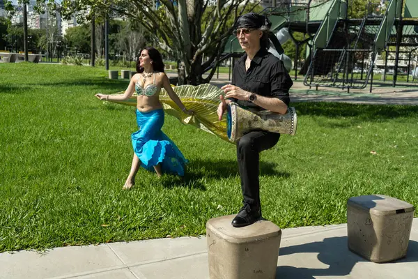 Odalisque ve darbuka oyuncusu Güneşin altındaki rüya gibi bir bahçede