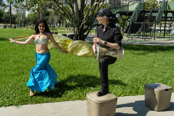 Bir Odalisque ve darbuka oyuncusu gündoğumunda enerji ve ritim dolu