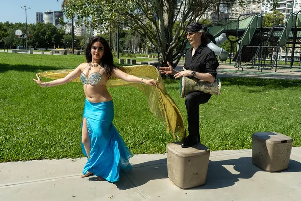 Odalisque ve darbuka oyuncusu Güneşin altındaki rüya gibi bir bahçede