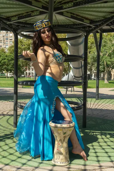 Gölgelerdeki Darbuka 'da mavi elbiseli bir Arap dansçı.