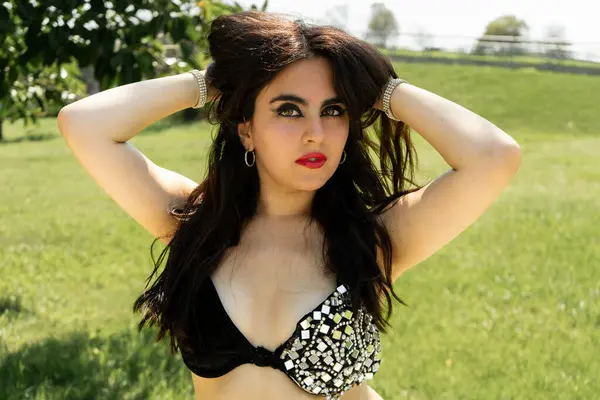 Siyah ve altın rengi bir Odalisque öğle güneşinin altında dans ediyor.