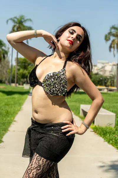 Siyah ve altın rengi bir Odalisque öğle güneşinin altında dans ediyor.