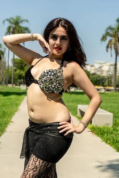 Siyah ve altın rengi bir Odalisque öğle güneşinin altında dans ediyor.