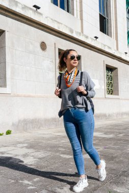Yeni bir şehirde tatilin tadını çıkarırken tarihi bir binanın yakınında yürüyen şık bir turist.