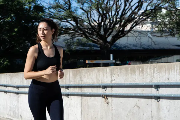 Şehir ortamında koşan sağlıklı bir kadın sağlıklı yaşam tarzını ve sağlığını destekliyor.