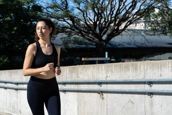 Şehir ortamında koşan sağlıklı bir kadın sağlıklı yaşam tarzını ve sağlığını destekliyor.