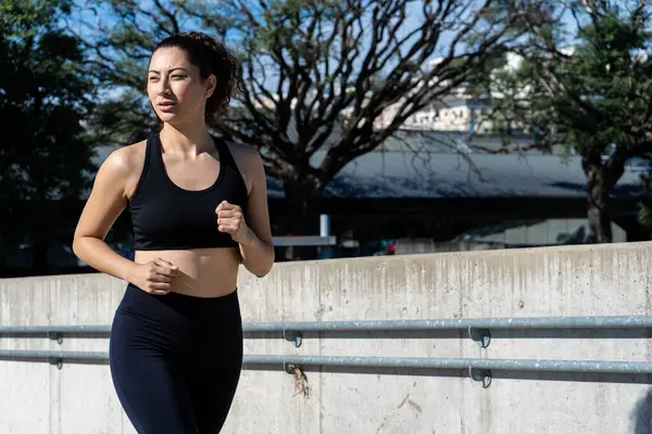 Şehirde koşmaya kararlı bir sporcu. Egzersiz rutininin tadını çıkarıyor.