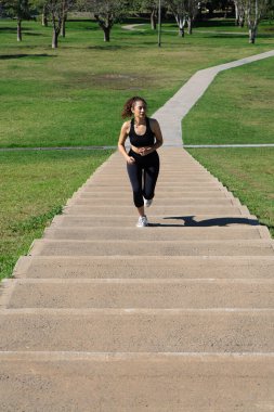 Kararlı bir sporcu parktaki merdivenlerden koşarak performansını geliştiriyor.