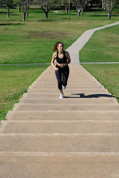 Kararlı bir sporcu parktaki merdivenlerden koşarak performansını geliştiriyor.