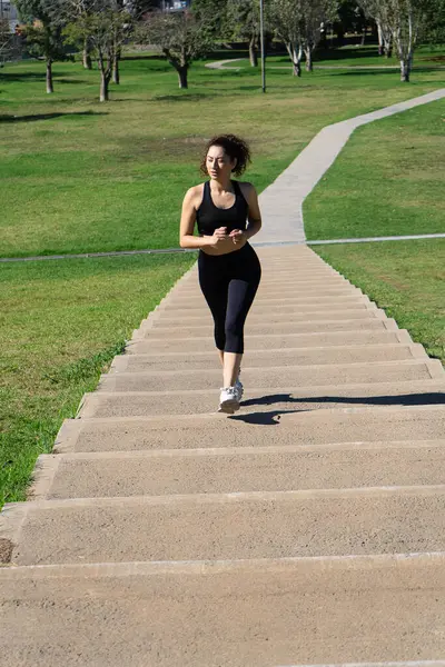 Kararlı bir sporcu parktaki merdivenlerden koşarak performansını geliştiriyor.