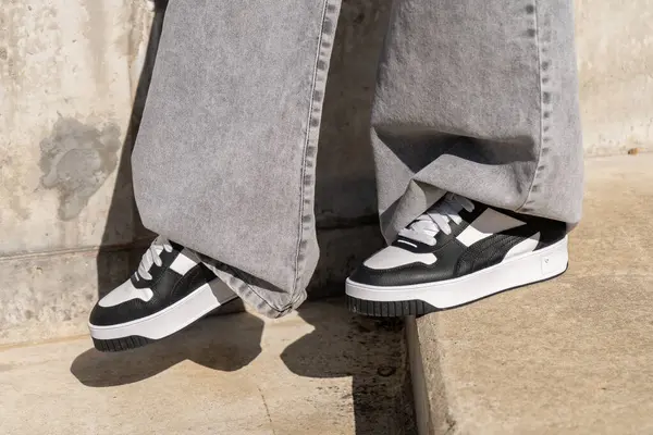 Model tarafından giyilen şık puma ca pro klasik spor ayakkabıları, beton basamaklarda şehir modasını gözler önüne seriyor.