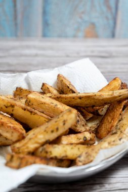 İştah açıcı, kavrulmuş, baharatlı ve otla tatlandırılmış patates dilimleri lezzetli ve görsel olarak çekici bir yemek yaratıyor.