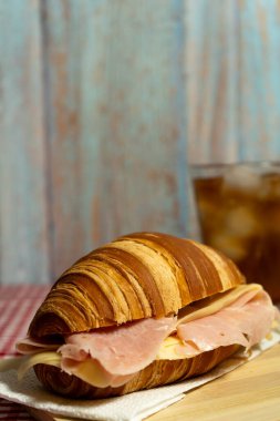 Lüks kafe tarzı kahvaltı erimiş peynirli kruvasan sandviçi porselen üzerinde servis edilir..