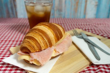 Lezzetli katmanlarını ortaya çıkarmak için tuzlu jambon ve yapışkan peynirle doldurulmuş altın rengi kruvasan. Fırın promosyonları veya brunch içeriği için ideal.