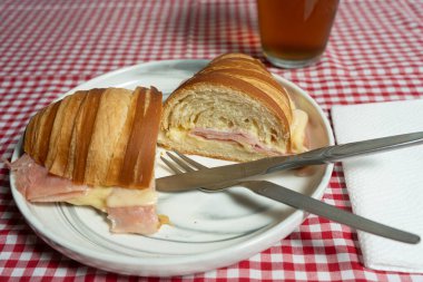 Jambon ve erimiş peynirle dolu çıtır kruvasan. İçini ortaya çıkarmak için dilimlenmiş. Gıda etkileri ve yemek tarifi videoları için harika..