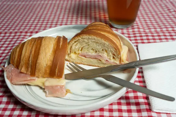 Jambon ve erimiş peynirle dolu çıtır kruvasan. İçini ortaya çıkarmak için dilimlenmiş. Gıda etkileri ve yemek tarifi videoları için harika..