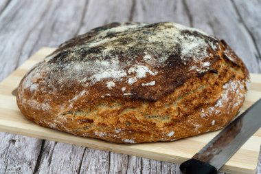 Ahşap bir yüzeyde taze pişmiş köy ekmeği dinleniyor.