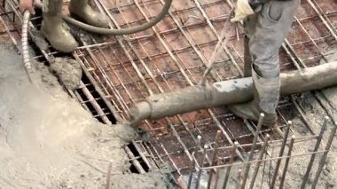 İnşaat işçileri metal şebekeye beton döküyorlar