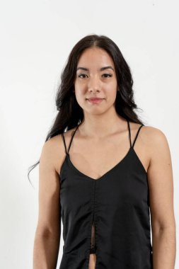 Siyah bir bluz giyen genç bir Latin kadının stüdyo portresi, kendine güven ve tarz yayıyor.