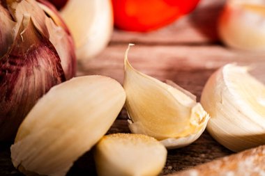 Canlı sarımsak soğanı ve karanfil yakın plan, doğal dokuları ve toprak tonlarını sergiliyor, aşçılık ve sağlıkla ilgili konular için mükemmel.