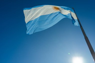 Arjantin bayrağı açık mavi gökyüzü ile güneşli bir günde dalgalanıyor