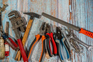 İngiliz anahtarı, çekiç, kerpeten, tornavida ve ahşap ahşap döşeme gibi farklı iş aletleri.