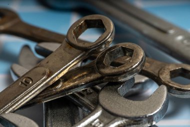 Krom vanadyum anahtarlar kareli bir tezgah yüzeyinde yatıyor. Tamircinin kullanması için hazır.