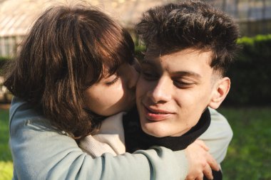 Romantik çift parkta güneşli bir günün tadını çıkarıyor, sevgi ve sevgiyi ifade ediyorlar.