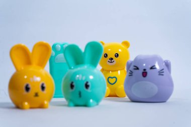 Tavşanlar, ayı ve kedi de dahil olmak üzere dört renkli kalem açacağı beyaz bir arka planda dinleniyor.