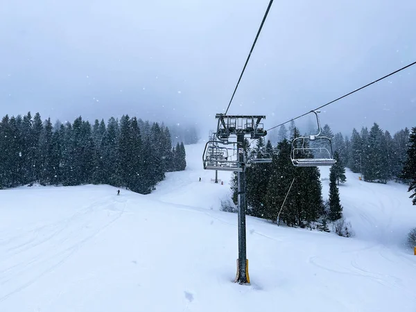 Ski Lift snowy mountain winter forest with chair lift At The Ski Resort in winter. Snowy weather Ski holidays Winter sport and outdoor activities Outdoor tourism skiing snowboarding