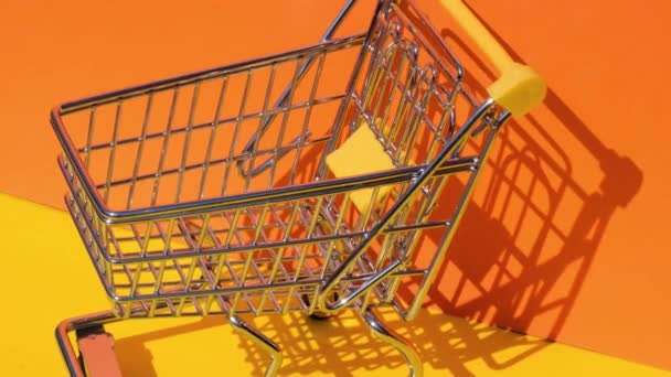Fügen Sie Dollar Banknote Geld Spielzeug Supermarkt Einkaufswagen Auf Gelbem — Stockvideo