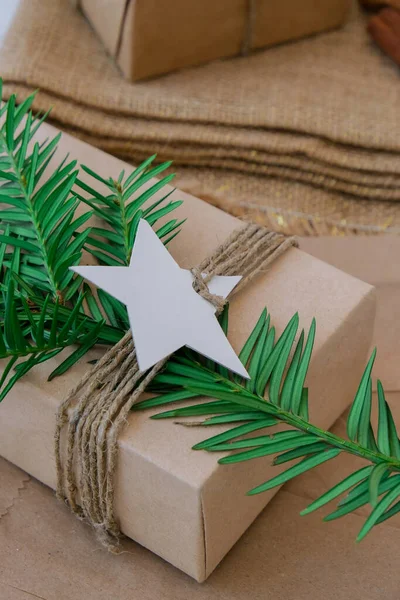 Box with New Year\'s gifts, wrapped in craft paper and decorated with fir branch. Holidays and Gifts concept. Handmade Eco friendly alternative green Christmas presents zero waste Sustainable lifestyle