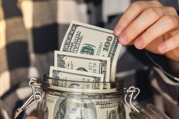 Dollar banknote saving money in glass jar. Unrecognizable woman moderate consumption and economy Collecting money. Tips. Business, finance, saving, banking and people concept. Extra money, passive