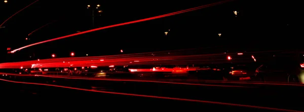 夜は車のライト 街路灯だ 夜の高速道路の街 長時間露光写真ナイトロード 道路上の赤い光の歩道の色のバンド 背景の壁紙に焦点を当てたぼやけた写真 バナーサイズコピースペース — ストック写真