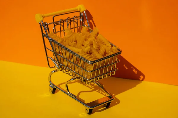 Wózek Sklepowy Wypełniony Makaronem Kolorowym Żółtym Pomarańczowym Tle Izometrycznym Skopiuj — Zdjęcie stockowe