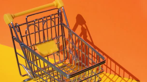 手加50欧元钞票在玩具超市购物车黄色背景的钱 销售一篮子欧元钞票 最低工资概念 投资养老金 储蓄资金融资 — 图库视频影像