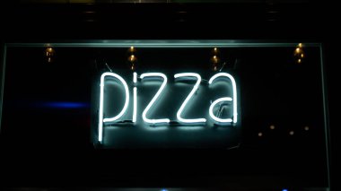 Geceleri neon ışıklarda pizza yazıları. Gece hayatı konseptinde elektrik tabelası. Modern floresan yaşam tarzı ışıldıyor. LED ışık işareti metin renk ışıklandırması