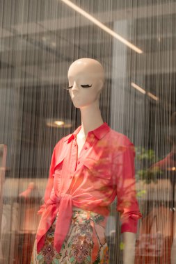 Mağaza vitrinleri ve mağazadaki kadın mankenler. Moda mağazasının dış görünüşü ile moda gösteren bluzlu yüzsüz kadın oyuncağı. Butik. Sokak dışından ön görünüm. 