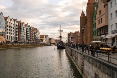Turistik gemi Gdansk 'ta eski bir kasabaya yelken açıyor. Turistli gemi Moltawa Nehri Cityscap 'taki Granary Adası yansıması için nehir kıyısına gidiyor. Eski bir vinç. Gdansk Polonya 'yı Ziyaret Et