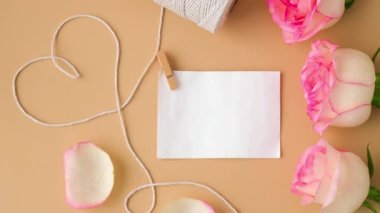 4k yakınlaştır Tender pembe gülleri, bej arka planda kalp şeklinde beyaz pamuk bir makarayla. Boş kağıt nota kopyalama alanı en az trend bileşimi. Romantik pastel pembe gül çiçekleri. Tarafsız