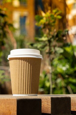 Eko-geridönüşüm kağıt bardağı, kahve ya da ahşap masadaki kraft kağıdına çay ile. Sokakta, parkta, bankta kahvaltı. Kahveyi paket yap. Uzayı metin için kopyala. Tek kullanımlık karton kahve.